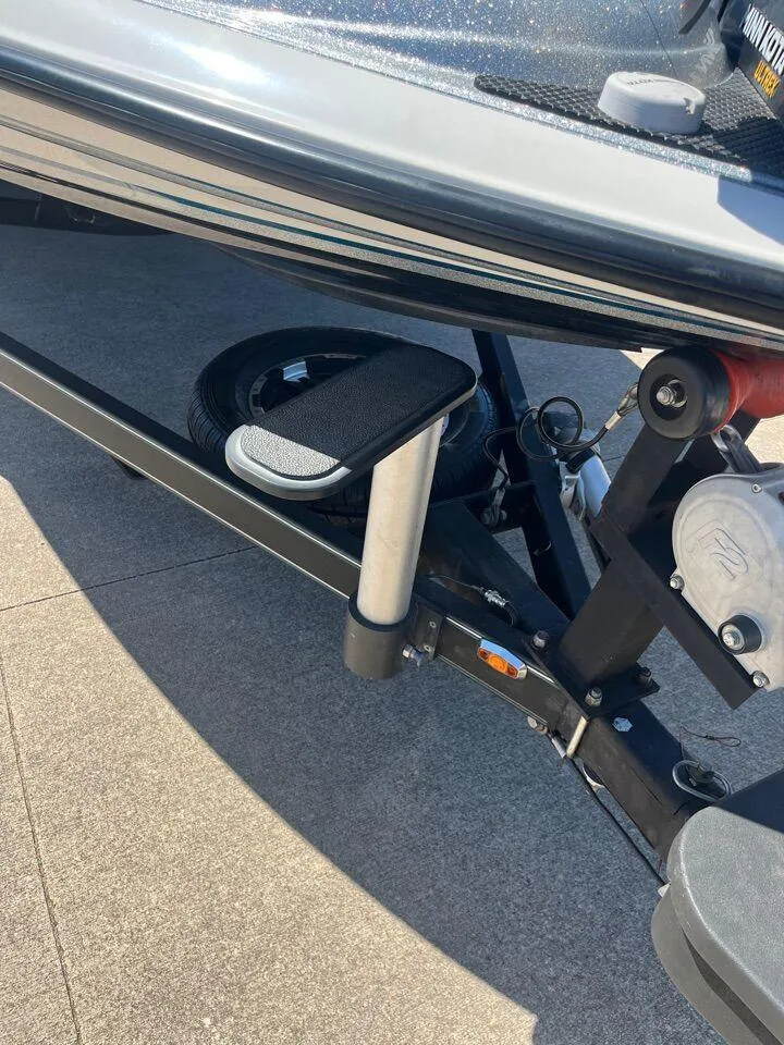 Slide: The Image of 2020 Triton 21 TRXS storage compartment with open lid and latch mechanism. - 31