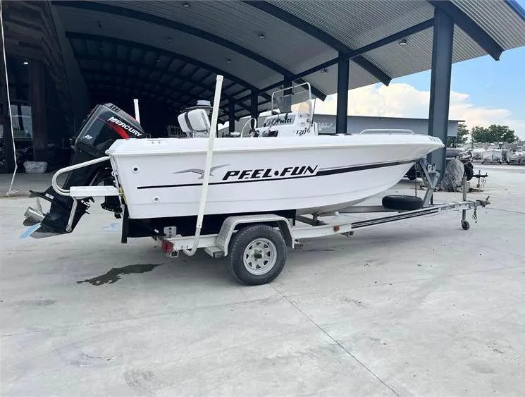 Slide: The Image of 1999 Pro-Line 170CC boat on trailer, side view, under covered area. - 2