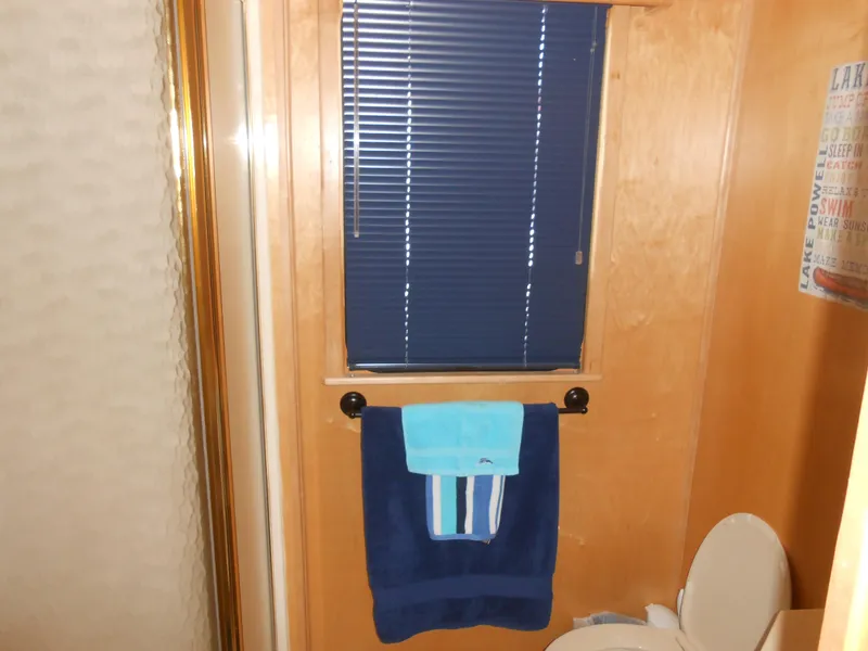 Slide: The Image of Bathroom interior of a 2001 Stardust Cruisers houseboat with blue blinds and towels. - 11