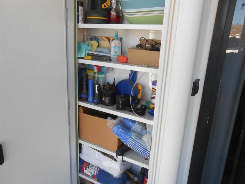 Slide: The Image of Storage closet on a 2001 Stardust Cruisers houseboat filled with various items. - 16