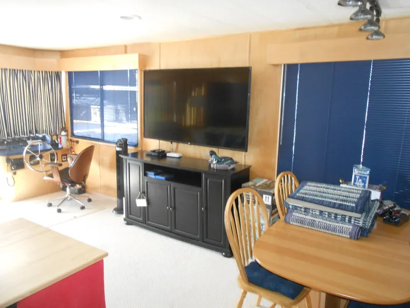Slide: The Image of Interior of 2001 Stardust Cruisers houseboat with TV, desk, and dining area. - 9