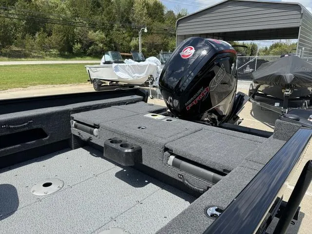 Slide: The Image of 2024 Lund 1775 Adventure Sport boat with Mercury outboard motor in a storage area. - 11