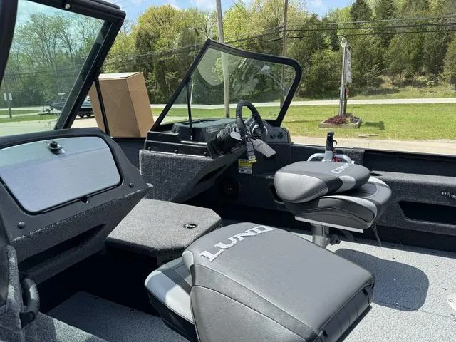 Slide: The Image of 2024 Lund 1775 Adventure Sport boat interior with steering wheel and seating. - 12