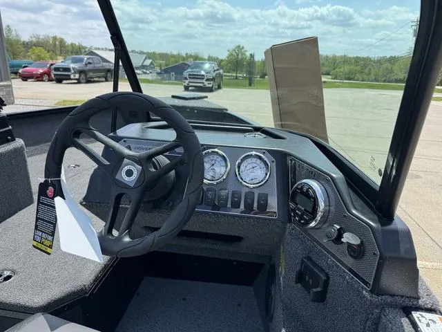 Slide: The Image of 2024 Lund 1775 Adventure Sport boat dashboard with steering wheel and gauges. - 4