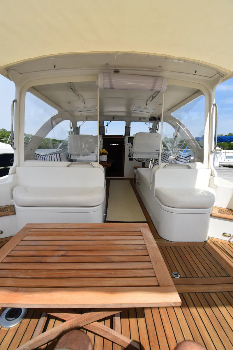 Slide: The Image of 2011 MJM 40z Downeast yacht interior with white seating and wooden table. - 11