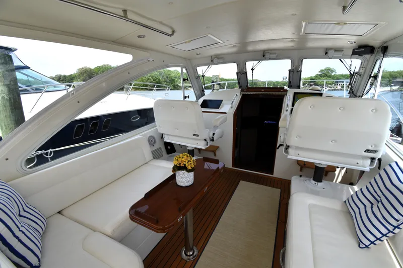 Slide: The Image of 2011 MJM 40z Downeast yacht interior with white seating and wooden table. - 13