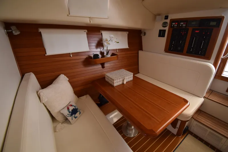Slide: The Image of 2011 MJM 40z Downeast yacht interior with wooden table and white seating. - 20