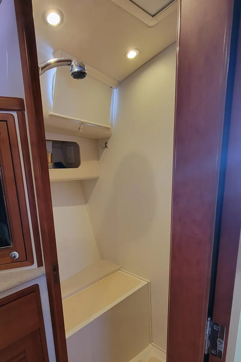 Slide: The Image of 2011 MJM 40z Downeast boat interior shower with wooden accents and built-in shelving. - 27
