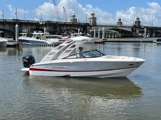 The Image of 2025 Regal LX2 boat on water near a bridge and marina. - 0