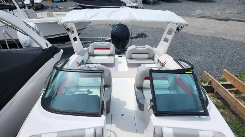 Slide: The Image of 2025 Regal LX2 boat interior with white and red seating, dual windshields, and spacious layout. - 11