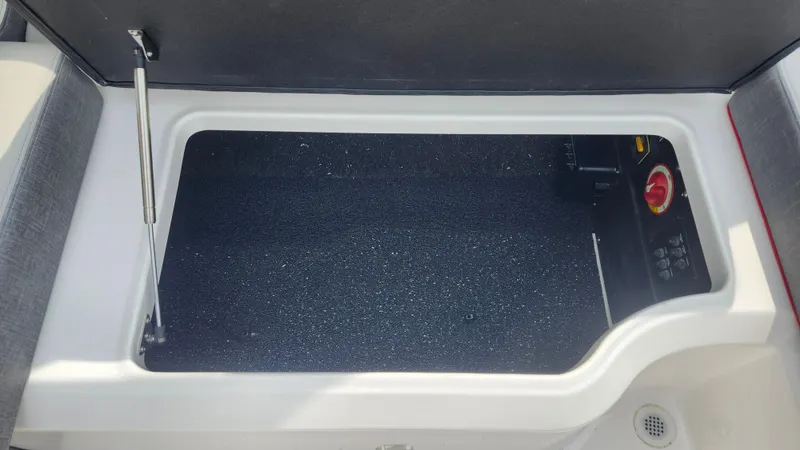 Slide: The Image of 2025 Regal LX2 boat interior with gray and white seating, red accents, and modern steering wheel. - 18