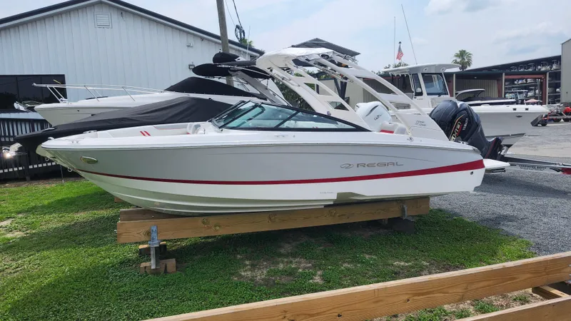 Slide: The Image of 2025 Regal LX2 boat displayed outdoors on wooden supports. - 4