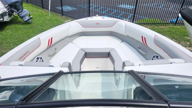 Slide: The Image of 2025 Regal LX2 boat interior with white seating and red accents, viewed from the cockpit. - 7