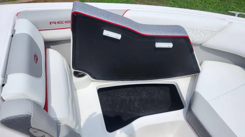Slide: The Image of 2025 Regal LX2 boat interior with open storage compartment and cushioned seating. - 9