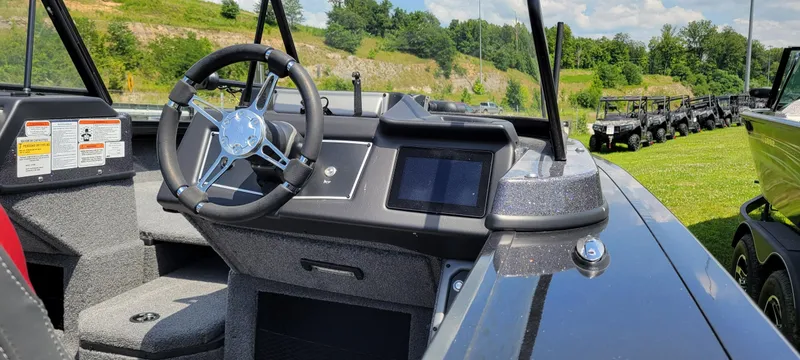 Slide: The Image of 2024 Ranger VX1988 WT boat dashboard with steering wheel and digital display, parked outdoors. - 3