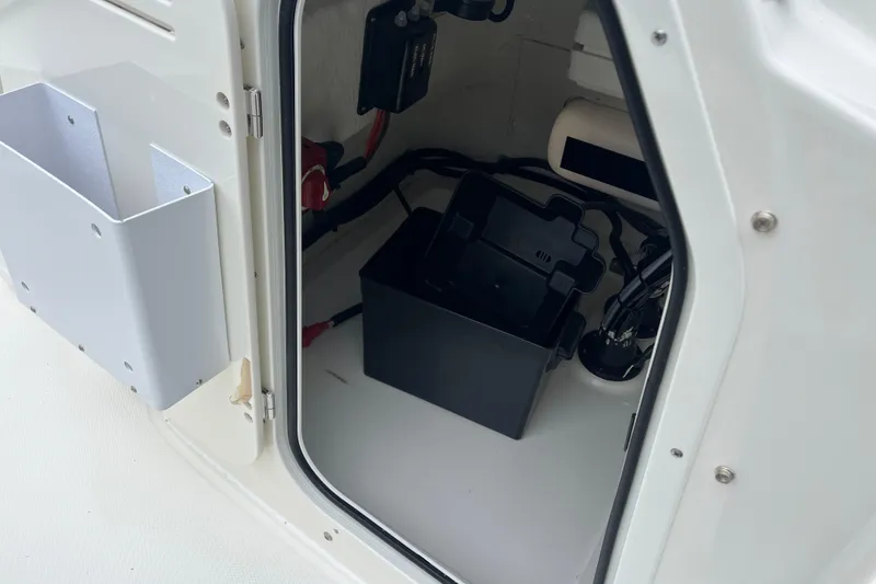 Slide: The Image of 2026 Boston Whaler 170 Montauk storage compartment with battery box and wiring. - 17