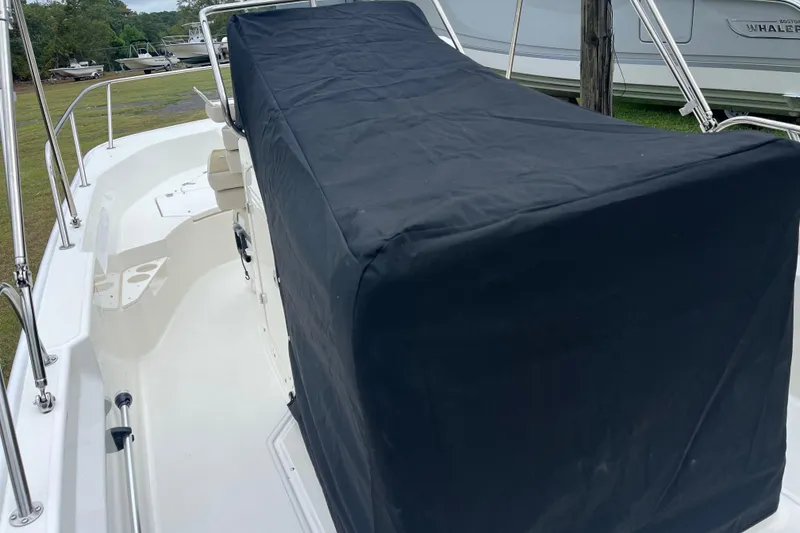 Slide: The Image of 2026 Boston Whaler 170 Montauk boat with covered console, parked outdoors. - 21