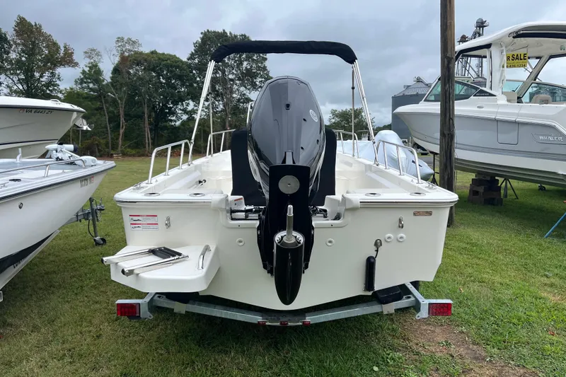 Slide: The Image of 2026 Boston Whaler 170 Montauk boat on trailer, rear view, outdoors. - 23