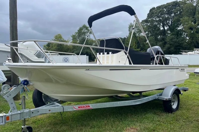 Slide: The Image of 2026 Boston Whaler 170 Montauk boat on trailer, parked on grass. - 26