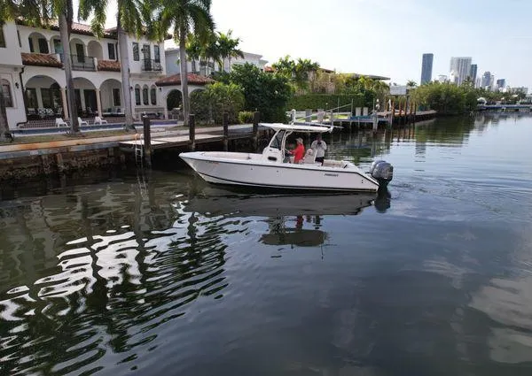 Slide: The Image of 2013 Pursuit C 260 Center Console boat cruising near waterfront homes. - 11