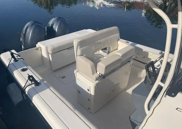 Slide: The Image of 2013 Pursuit C 260 Center Console boat with twin engines docked on calm water. - 18