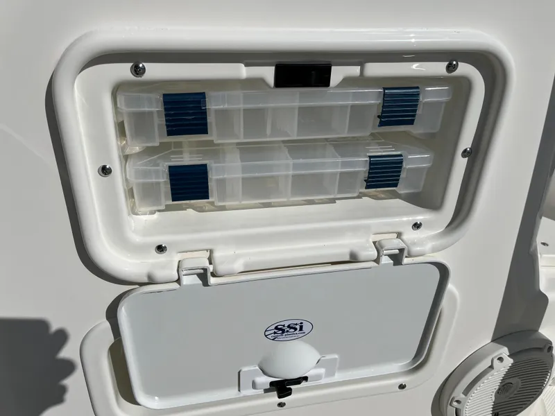 Slide: The Image of Storage compartment on a 2025 Boston Whaler 190 Montauk boat, featuring organized tackle boxes. - 18