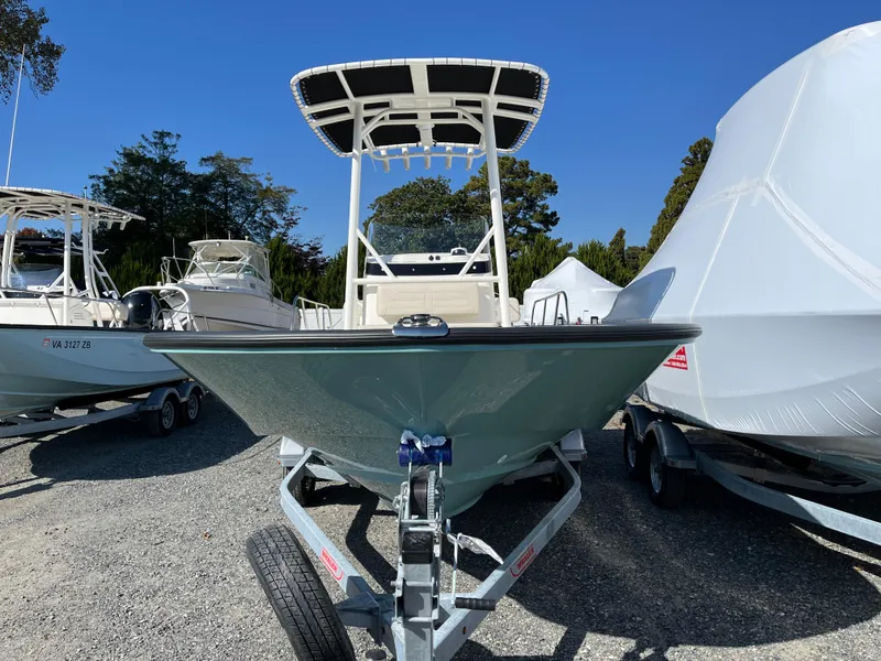 Slide: The Image of 2025 Boston Whaler 190 Montauk boat on trailer, parked outdoors under clear blue sky. - 28