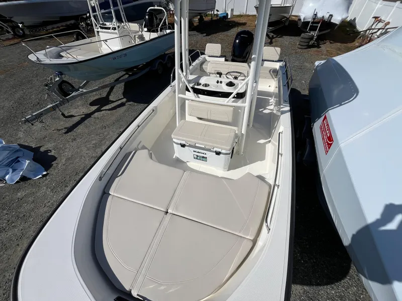 Slide: The Image of 2025 Boston Whaler 190 Montauk boat, top view, parked on gravel lot. - 3
