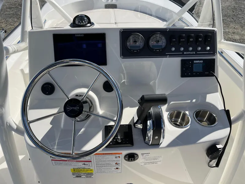 Slide: The Image of 2025 Boston Whaler 190 Montauk boat dashboard with steering wheel and controls. - 5