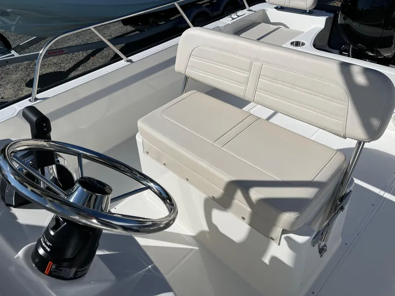 Slide: The Image of 2025 Boston Whaler 190 Montauk boat interior with steering wheel and cushioned seating. - 9