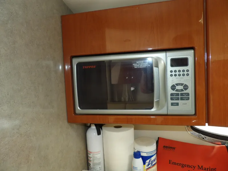 Slide: The Image of Microwave in 2008 Formula 31 Performance Cruiser galley with fire extinguisher and cleaning supplies. - 46