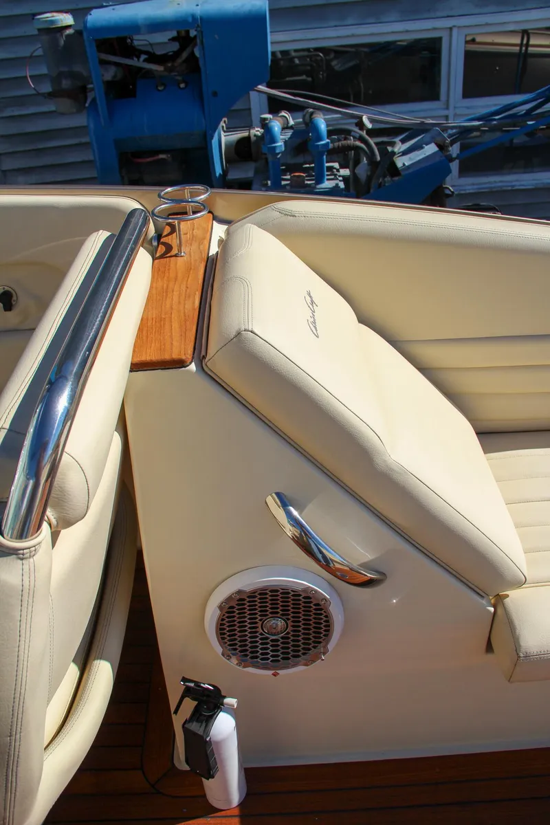 Slide: The Image of 2013 Chris-Craft Launch 32 boat on lift, showcasing sleek design and dual engines. - 23