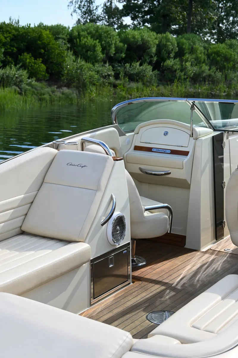 Slide: The Image of 2013 Chris-Craft Launch 32 dashboard with Raymarine navigation and wooden steering wheel. - 43