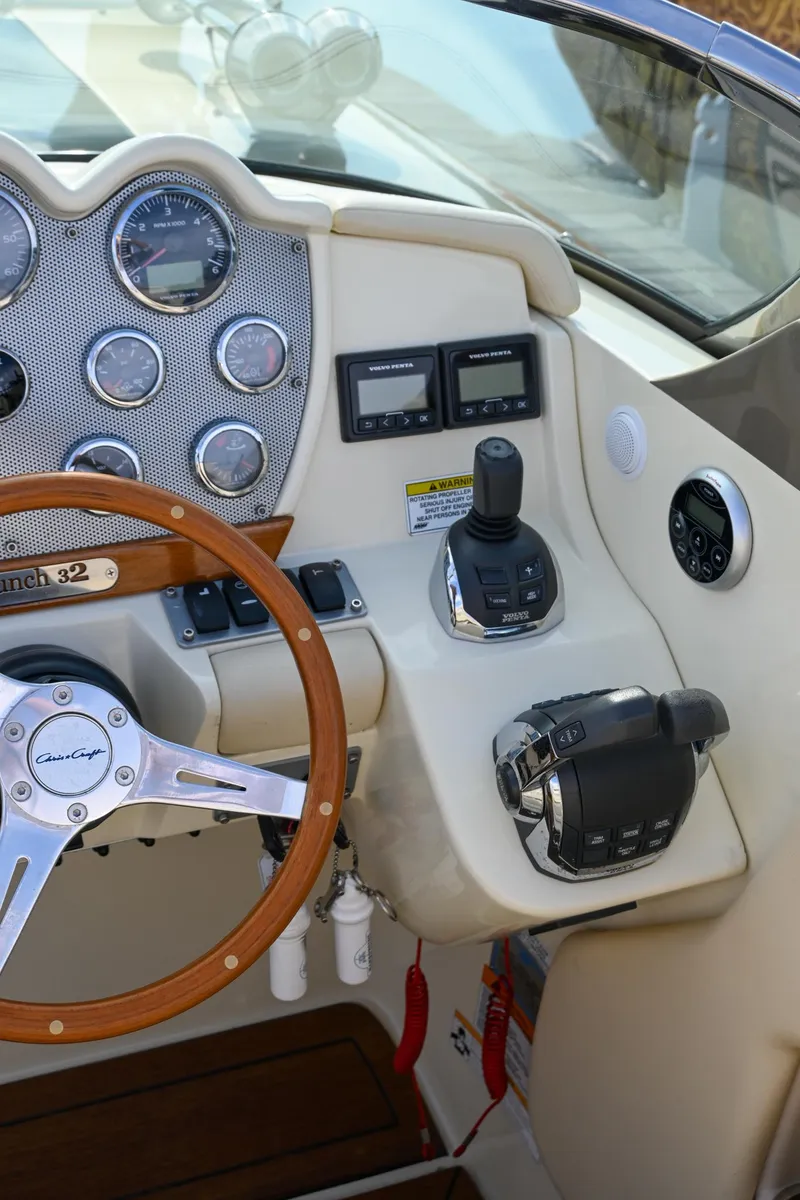 Slide: The Image of 2013 Chris-Craft Launch 32 boat with American flag on calm water. - 48