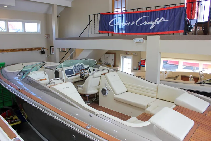 Slide: The Image of 2013 Chris-Craft Launch 32 boat displayed indoors, featuring luxurious seating and elegant design. - 58