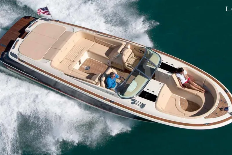 Slide: The Image of 2013 Chris-Craft Launch 32 boat cruising on clear blue water, featuring elegant design and spacious seating. - 69