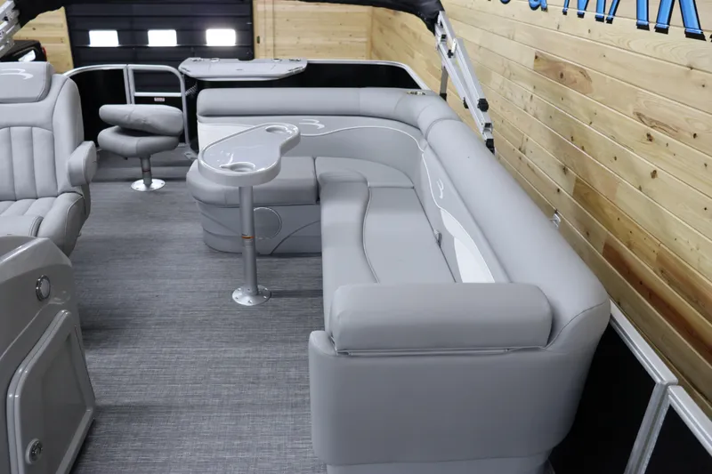 Slide: The Image of 2024 Bennington 20 SFNP pontoon boat interior with gray seating and wood paneling. - 11