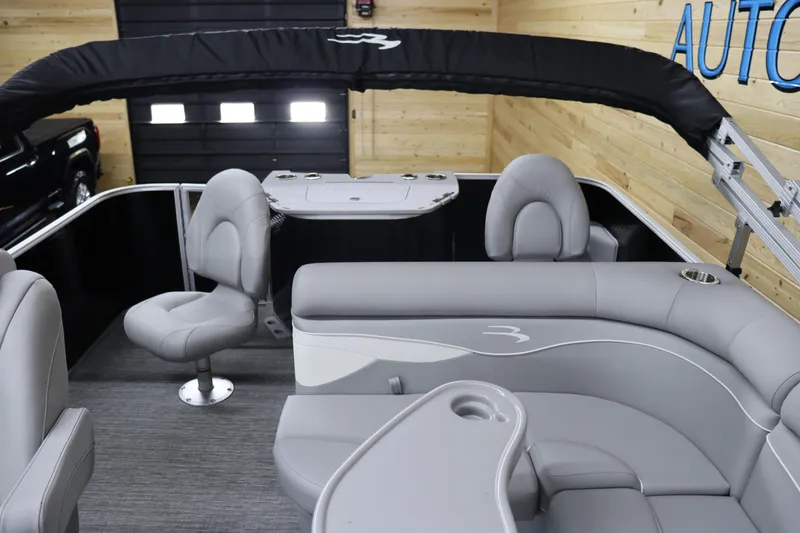Slide: The Image of 2024 Bennington 20 SFNP pontoon boat interior with gray seating and black canopy. - 13