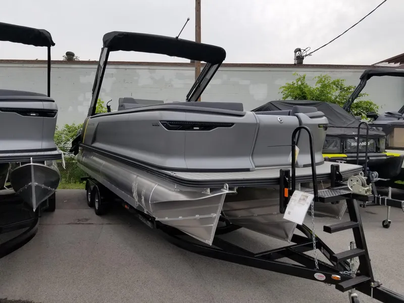 Slide: The Image of 2023 Manitou Explore Navigator 24 with Trifold Bench - SHP575 pontoon boat on trailer. - 1