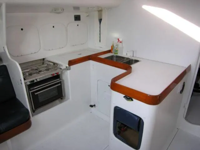 Slide: The Image of 1993 Green Marine Dubois 50 yacht kitchen with stove, sink, and white cabinetry. - 15