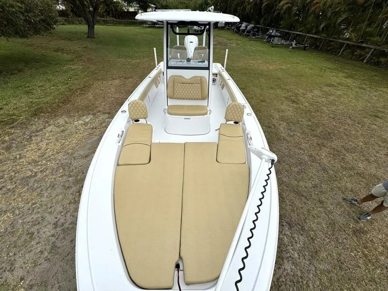 Slide: The Image of 2023 Sportsman Masters 267 Bay boat with tan seating on grassy area. - 15