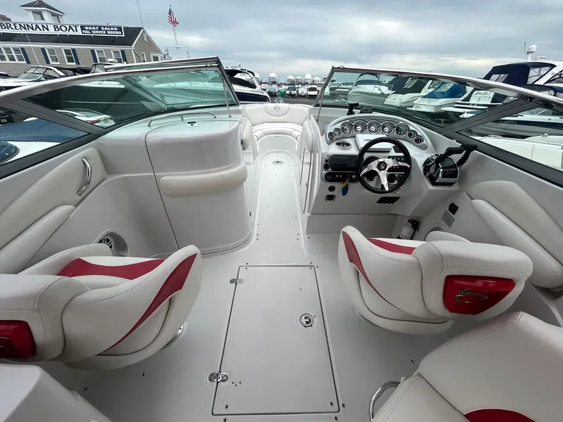Slide: The Image of 2009 Crownline 300 LS boat interior with white and red seating, dashboard, and steering wheel. - 10