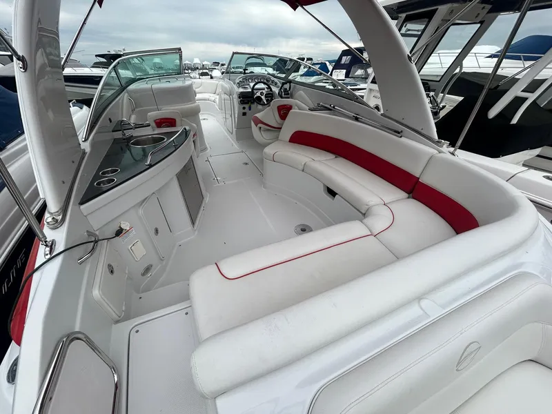 Slide: The Image of 2009 Crownline 300 LS boat interior with white and red seating, kitchenette, and helm. - 15