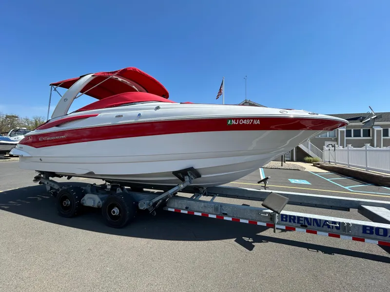 Slide: The Image of 2009 Crownline 300 LS boat with red and white exterior on a trailer. - 2