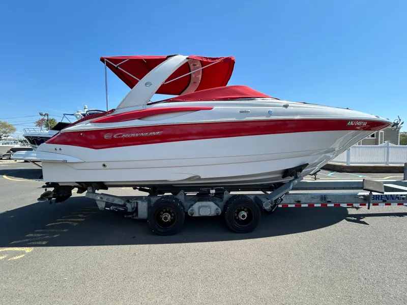 Slide: The Image of 2009 Crownline 300 LS boat with red and white exterior on a trailer. - 5