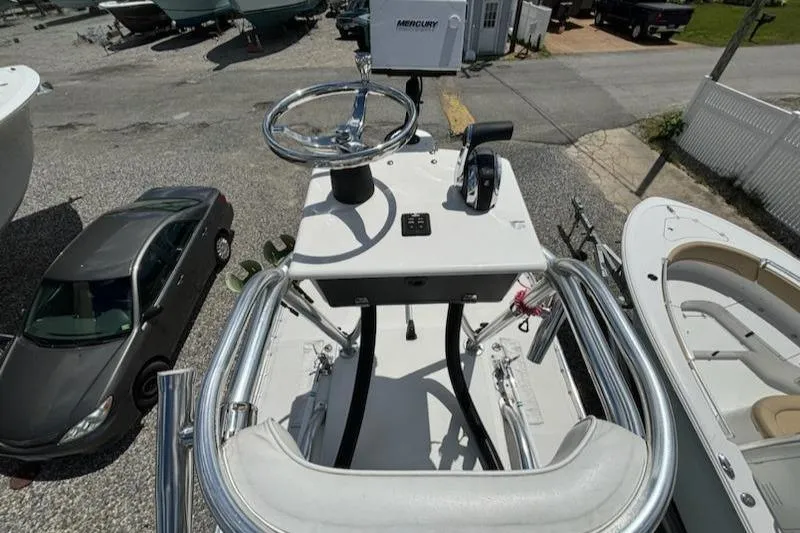 Slide: The Image of 2008 Contender 23 Tournament boat helm with Mercury controls, parked near a car. - 15