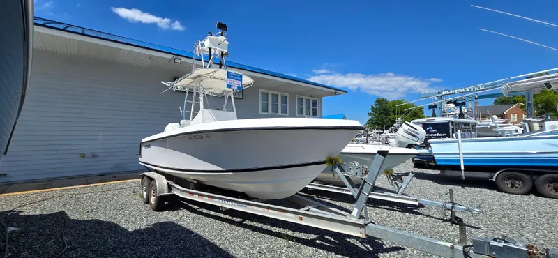 Slide: The Image of 2008 Contender 23 Tournament boat on trailer, parked outdoors under clear blue sky. - 20