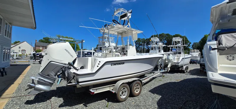 Slide: The Image of 2008 Contender 23 Tournament boat on trailer in marina under clear blue sky. - 21