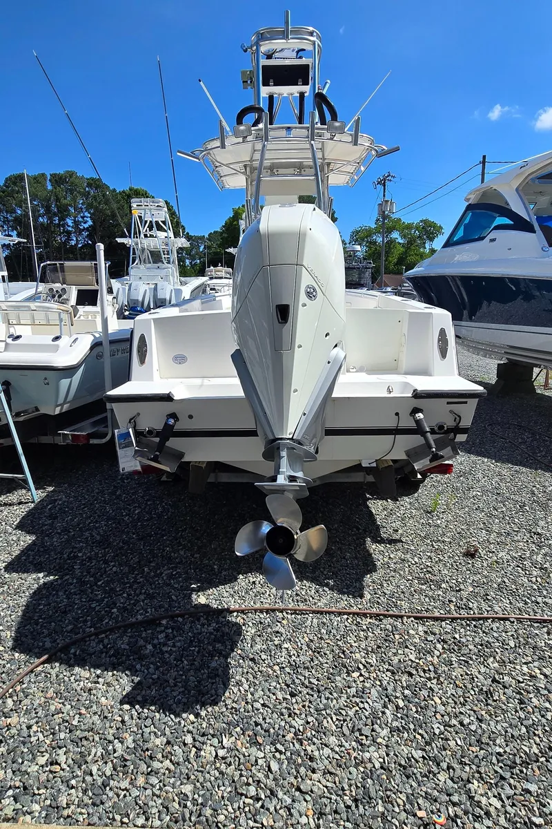 Slide: The Image of 2008 Contender 23 Tournament boat, rear view, parked on gravel with other boats nearby. - 23