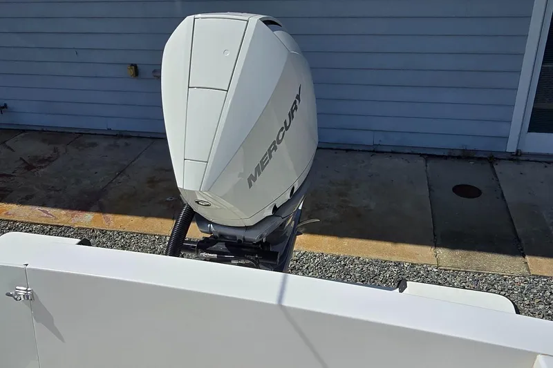 Slide: The Image of Outboard motor on a 2008 Contender 23 Tournament boat, parked by a blue wall. - 27